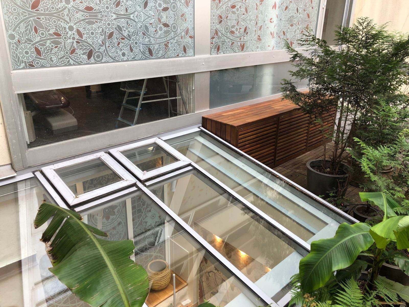 Vue en plongée sur la verrière et le bandeau vitré décoré du cabinet dentaire